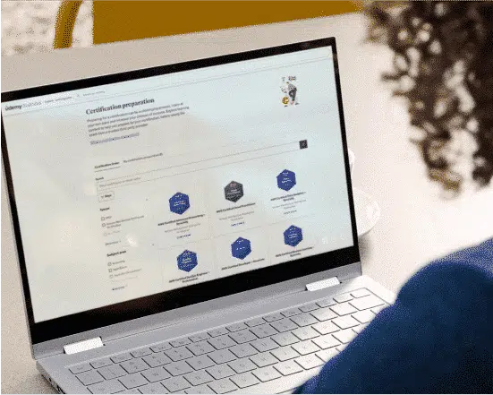 Person with curly hair researching certification preparation solutions on their laptop