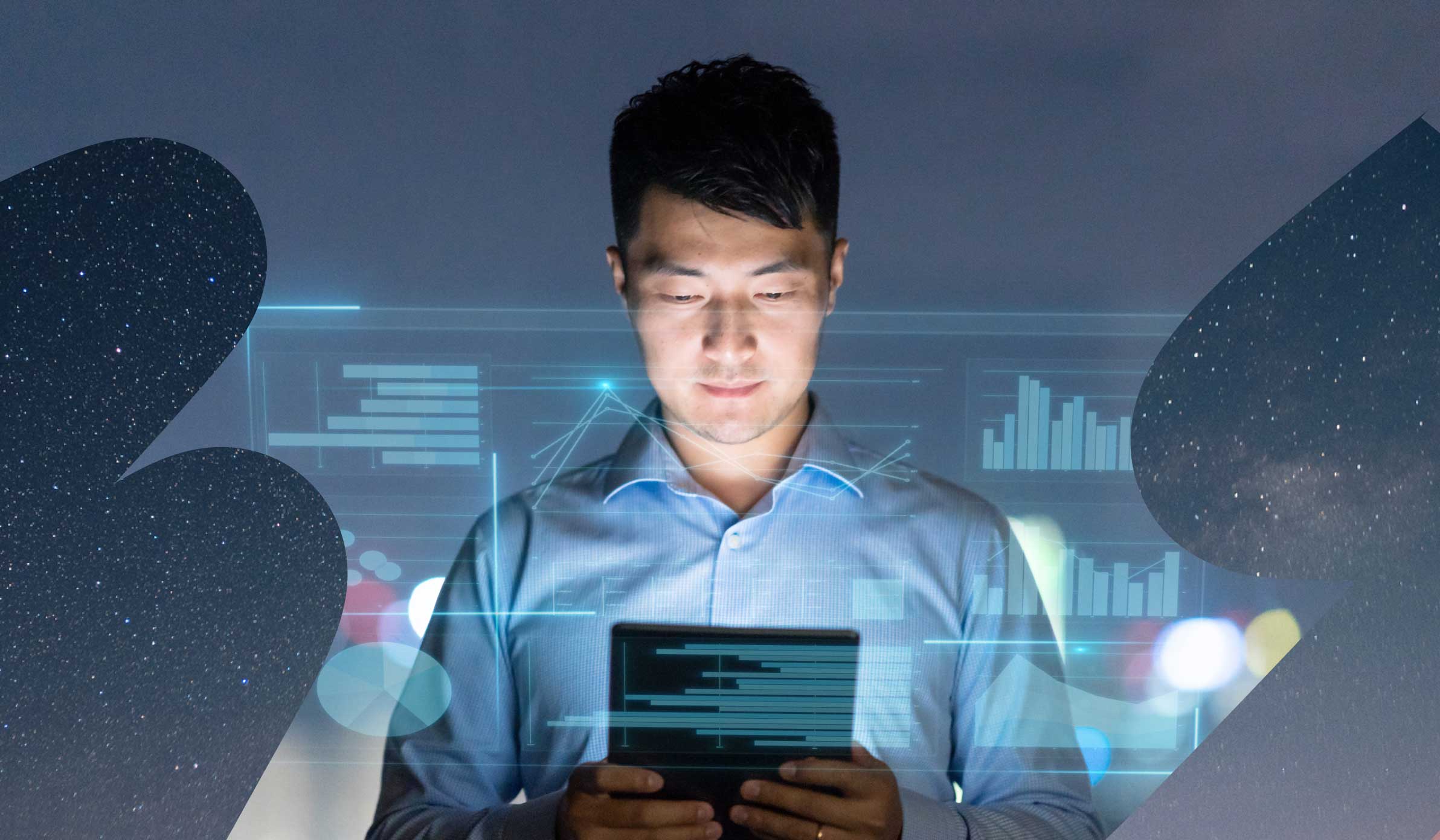 Man with short, dark hair in business casual clothing looking at his tablet screen, surrounded by graphs and charts
